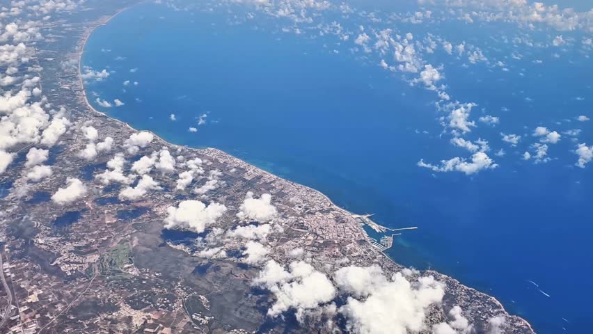 Stunning aerial imagery that beautifully showcases a vibrant coastal scene featuring deep blue waters and fluffy clouds