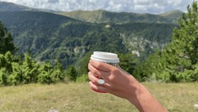 Landscape lifestyle video of a woman enjoying a coffee moment in Montenegro with a stunning oval diamond engagement ring sparkling in the natural light and mountain view. - Powered by Shutterstock - Get 15% off with code: PIKWIZARD15