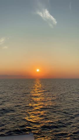 stunning sea voyage footage at sunset with golden light reflecting on the calm sea