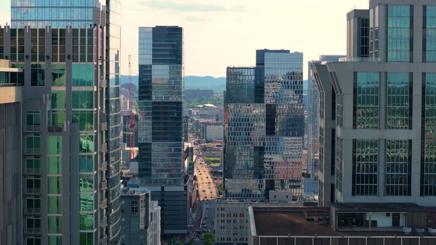 Aerial view of Nashville, Tennessee city center with tall office towers, bustling streets and contemporary skyline.
