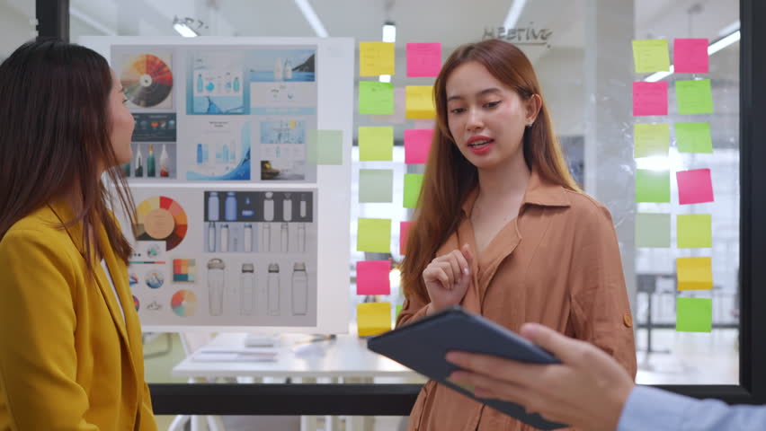 Asian business creative agency team brainstorms and shares innovative ideas together in a modern office interior, preparing presentation strategy with agile thinking and resilient teamwork to drive