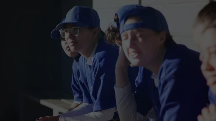 Adult female baseball team sitting bench blue helix entering sweeping across showing sports tech. Athletes, teamwork, innovation, technology, training, fitness, digital - Powered by Shutterstock - Get 15% off with code: PIKWIZARD15