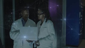 IT engineers opening laptop and pointing while reviewing pulsing network overlay inside server room. Technology, collaboration, data, innovation, digital, enterprise, cybersecurity - Powered by Shutterstock - Get 15% off with code: PIKWIZARD15