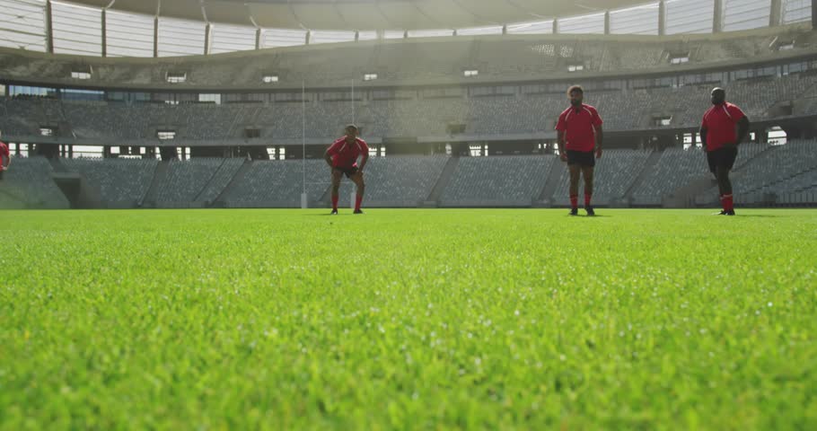 Red-clad athletes running as social media badges stacking, falling ball igniting leap securing ball. Athletes, sports, teamwork, competition, stadium, digital, engagement