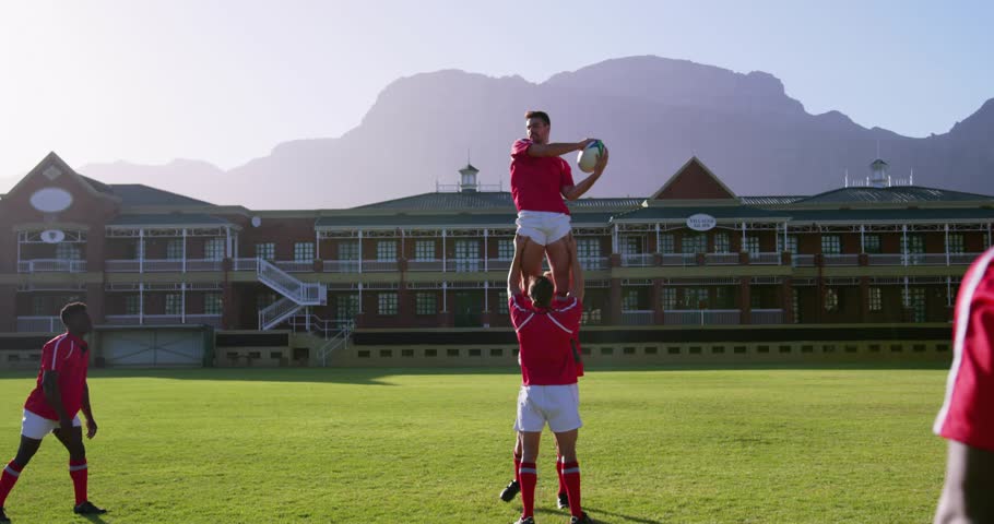 Match official throwing ball in enabling lifting jumper catching rugby ball passing for support run. Teamwork, athleticism, motion, outdoor, vibrant, dynamic, competition