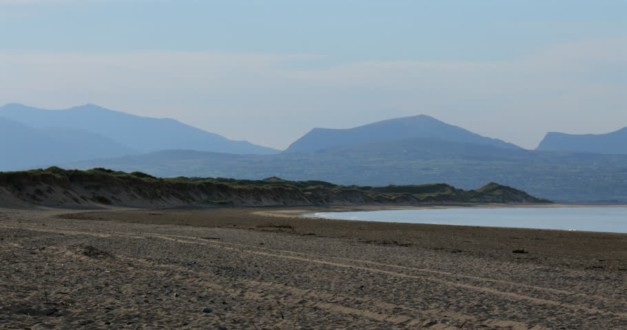 wide shot panning shot left to right looking east of Llanddwyn beach at the Newborough National Nature Reserve.