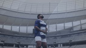 Male athlete gripping rugby ball activating hologram overlay tossing engaging sports tech interface. Athlete, stadium, digital graphics, futuristic, sports, technology, innovation - Powered by Shutterstock - Get 15% off with code: PIKWIZARD15