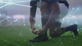 Kneeling soccer player tightening cleat laces on turf, activating analytics for match readiness. Athlete, sportswear, modern design, performance, fitness, stadium, determination - Powered by Shutterstock - Get 15% off with code: PIKWIZARD15