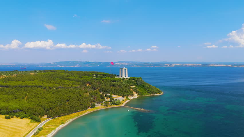 Eceabat, Turkey. The Canakkale Martyrs Memorial stands majestically on Hisarlik Hill, Turkish flag waving the backdrop of the Dardanelles Strait on a clear sunny day. Aerial view. Stable. Aerial View