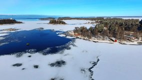 Aerial drone view of ice blue lake water and red log cabin or cottage in winter Finland  - Powered by Shutterstock - Get 15% off with code: PIKWIZARD15