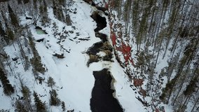 Aerial drone flight of cold canyon river and snow winter forest in Finland, Lapland - Powered by Shutterstock - Get 15% off with code: PIKWIZARD15