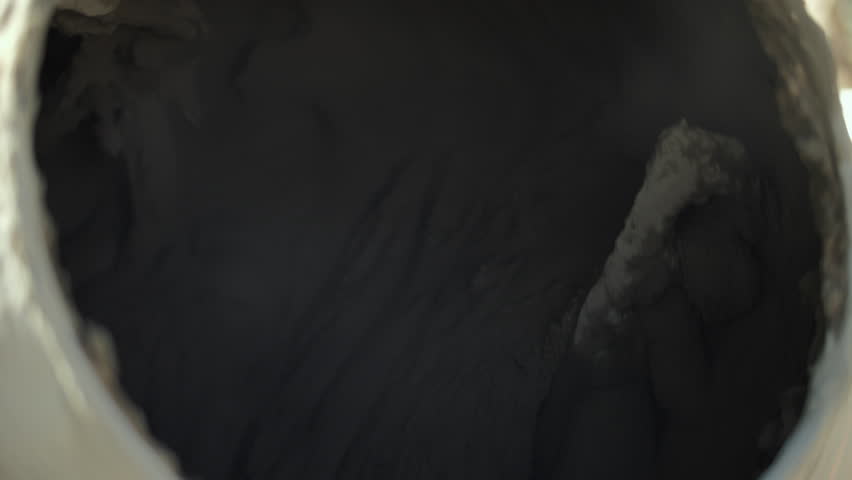 Inside rotating drum of concrete mixer with wet cement