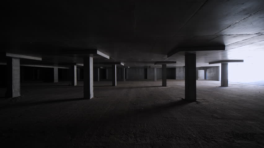 Dark unfinished underground parking with concrete columns