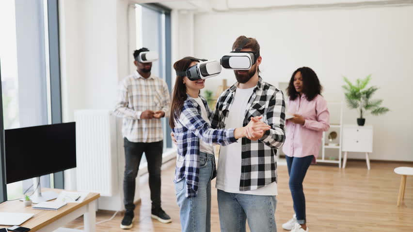 Young adults wearing VR headsets engaged in interactive activity, simulating dance and entertainment. Group consisting of men and women having fun with innovative wearable technology. - Powered by Shutterstock - Get 15% off with code: PIKWIZARD15