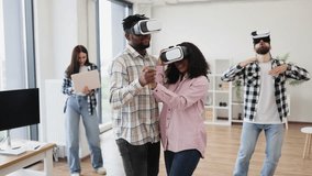 Diverse group of young men and women enjoying time using virtual reality glasses celebrating together indoors. - Powered by Shutterstock - Get 15% off with code: PIKWIZARD15