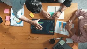 Top view of skilled project manager talking about financial graph to investors while sitting at meeting table with data analysis document. Diverse team discussing and brainstorming idea. Convocation. - Powered by Shutterstock - Get 15% off with code: PIKWIZARD15