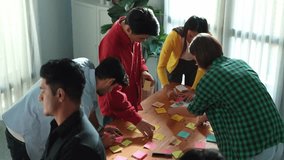 Top view of smart business team brainstorm idea while writing idea in colorful sticky notes. Attractive diverse people in casual cloth planning strategy and brainstorming marketing plan. Convocation. - Powered by Shutterstock - Get 15% off with code: PIKWIZARD15