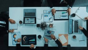 Top down aerial view of smart business woman handing out financial document to diverse team while discuss or brainstorm about marketing strategy with investment chart display on tablet. Directorate. - Powered by Shutterstock - Get 15% off with code: PIKWIZARD15