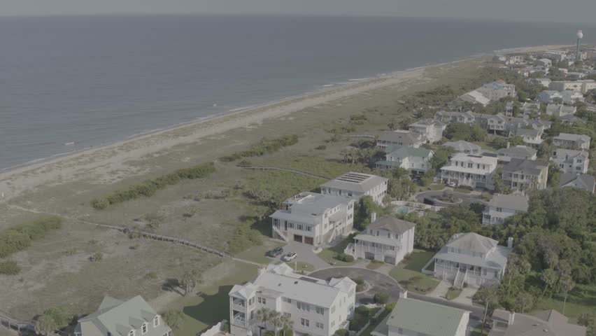 Beautiful 4K aerial drone footage showcasing luxurious waterfront homes on Hilton Head Island, South Carolina. The sweeping cinematic shot captures elegant coastal architecture surrounded by calm blue