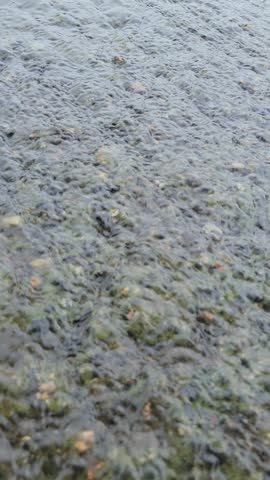 Close up on water sliding down rock hill