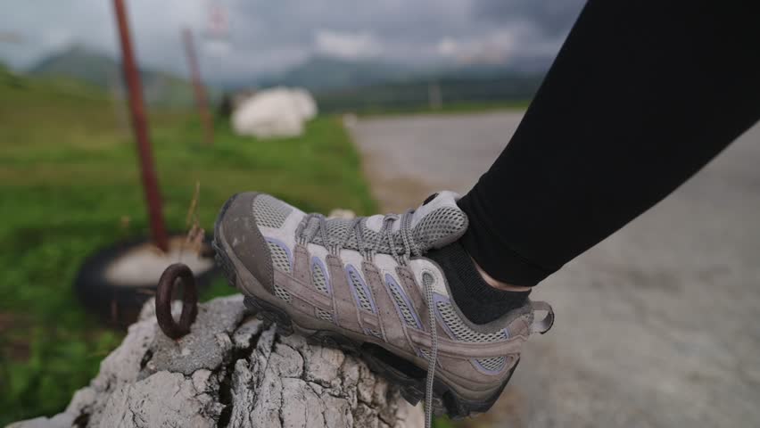 Tightening hiking boots on stone by alpine trail in the Dolomitines Alpes