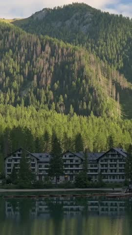 Vertical screen of Lago di Braies of scenic mountain landscape with forest and lakeside hotel