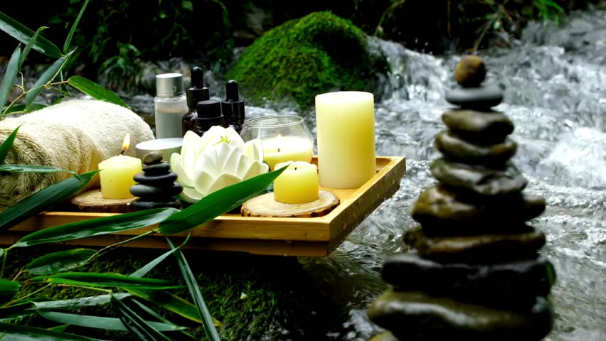 Spa setting with candles, essential oils, and zen stones by a serene, flowing stream. A tranquil scene for relaxation, wellness, meditation, and natural beauty. - Powered by Shutterstock - Get 15% off with code: PIKWIZARD15