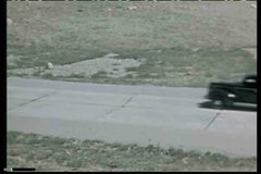 1930s - A car drives along a road near Salt lake City, Utah in the 1930' and across the salt flats.
