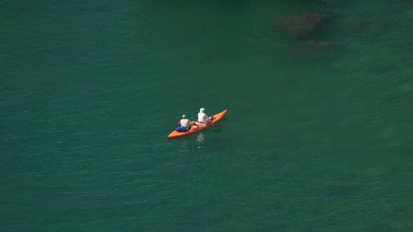 Kayaking, Lake, People - Two people kayaking on a calm lake, enjoying the serene water and scenic views.
