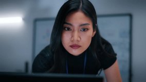 Female Software Engineer, Computer Programmer sits at desk Writing Code on Desktop computer with Dual Screens at Tech Office at Night. Professional female IT expert working on Software Code Program. - Powered by Shutterstock - Get 15% off with code: PIKWIZARD15