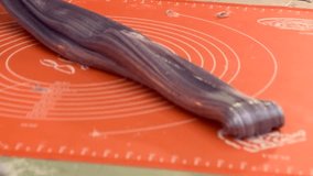 Skilled craftsperson makes colorful spiral lollipops. Hands shape, cut, and finish sweet candies from vibrant sugar dough on a white mat. Artisan confectionery making process. - Powered by Shutterstock - Get 15% off with code: PIKWIZARD15