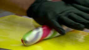 Skilled craftsperson makes colorful spiral lollipops. Hands shape, cut, and finish sweet candies from vibrant sugar dough on a white mat. Artisan confectionery making process. - Powered by Shutterstock - Get 15% off with code: PIKWIZARD15