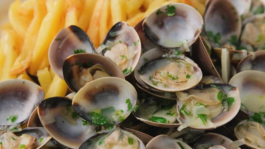 Steamed Clams with herbs and French fries in a white plate