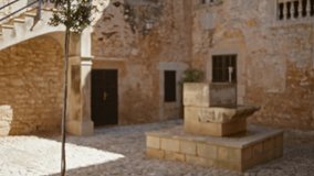 Blurry image of an old campus courtyard with stone walls and a central fountain under a bright sky, creating a serene historic ambiance. - Powered by Shutterstock - Get 15% off with code: PIKWIZARD15