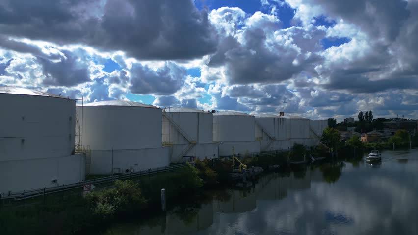 Decommissioning of Storage depot for petroleum products storage silos and containers. Industrial storage tanks holding oil and gas products. Dramatic aerial view flight ascending drone