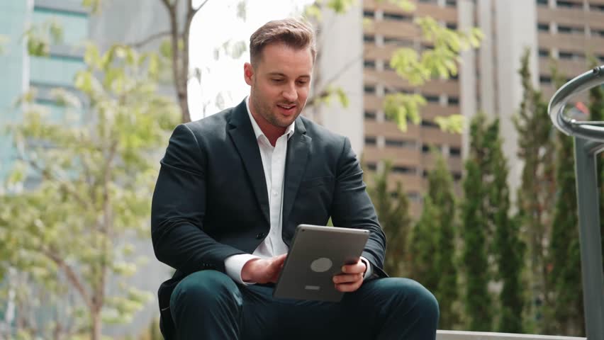 Close up of business people working on tablet while sitting at green city. Low angle camera of manager using his tablet to browsing and searching financial data analysis while remote working. Urbane. - Powered by Shutterstock - Get 15% off with code: PIKWIZARD15