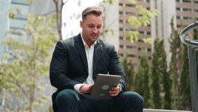 Close up of business people working on tablet while sitting at green city. Low angle camera of manager using his tablet to browsing and searching financial data analysis while remote working. Urbane. - Powered by Shutterstock - Get 15% off with code: PIKWIZARD15
