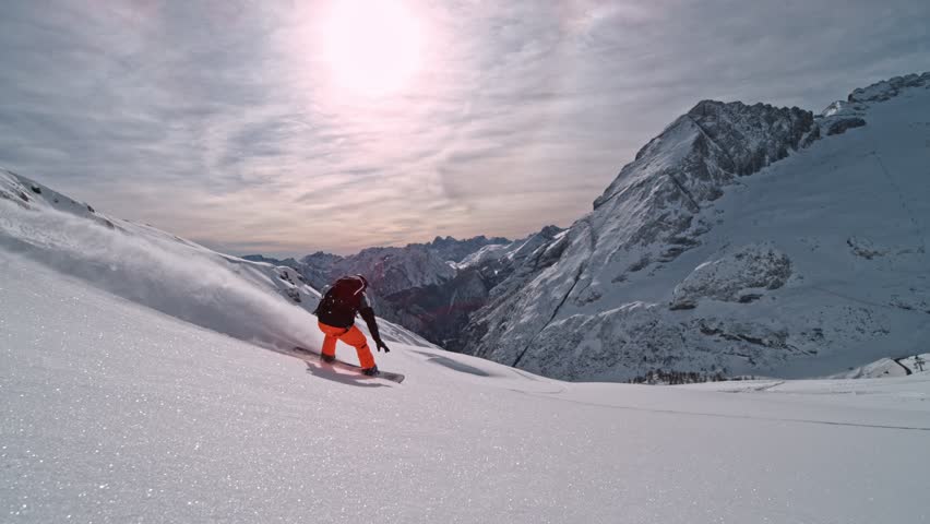 Off Piste Snowboarder Running Down. Super Slow Motion, 1000 fps. Snowboarding on Free Ride off Piste Slope in European Dolomites Mountains, Italy. 