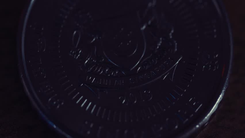 Macro close-up of a Singapore dollar coin, highlighting intricate engravings, metallic texture, and the detailed design of currency for commerce and finance.