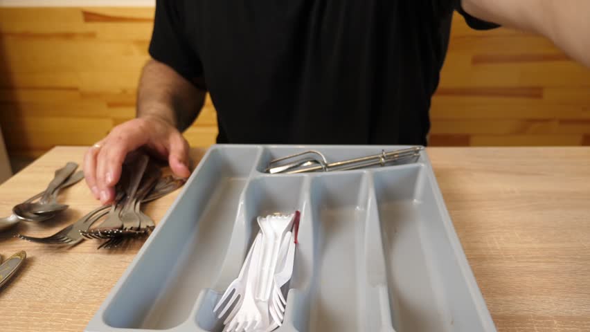 Kitchen spoons, forks and knives are placed in a tray
