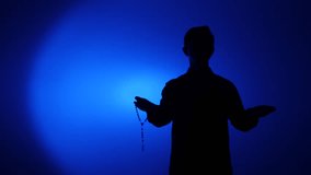 Man silhouette holding rosary bead praying to god. themes of spirituality and reverence - Powered by Shutterstock - Get 15% off with code: PIKWIZARD15