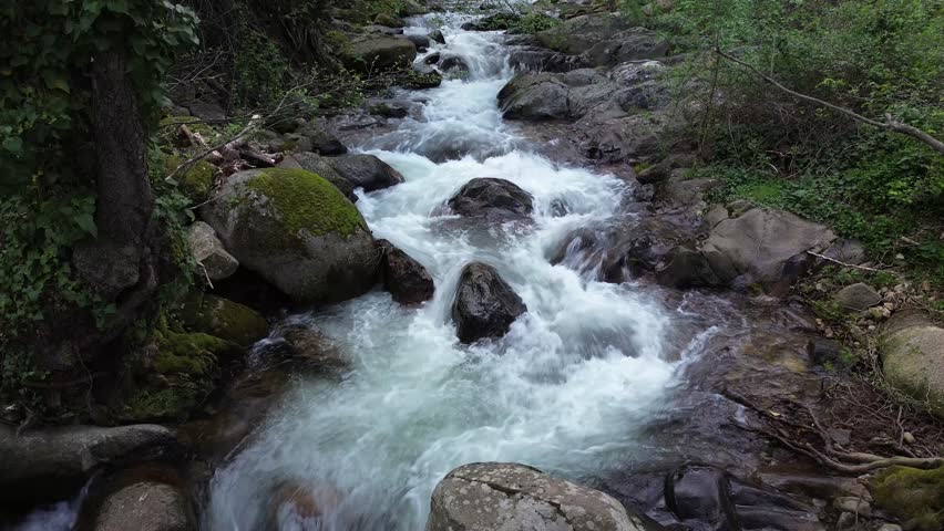 crystal clear waters flow from a mountain river between the rocks