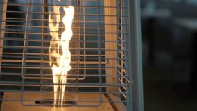 Dramatic outdoor patio heater flame dancing in vertical grate during twilight - Powered by Shutterstock - Get 15% off with code: PIKWIZARD15