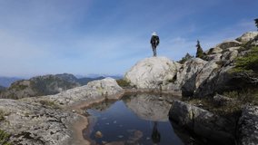 Adventurous Hiker on Rocky Summit Overlooking Stunning North Vancouver Mountains and Reflective Alpine Pond - Powered by Shutterstock - Get 15% off with code: PIKWIZARD15