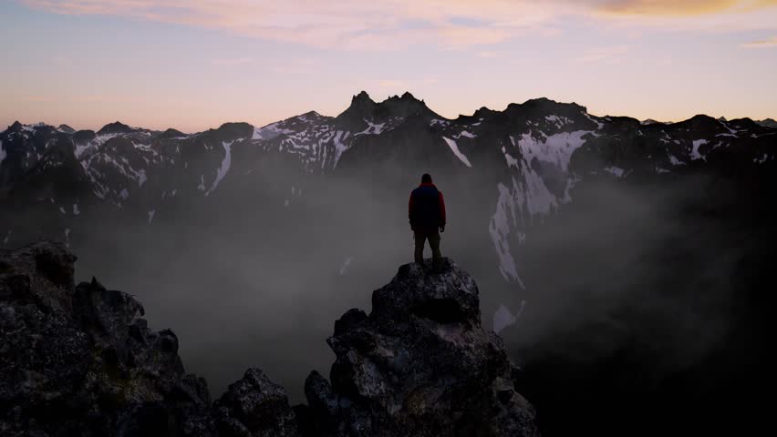 Hiker Stands Victorious on a Digital Mountain Peak, Overlooking a Vast Rendered Landscape at Dawn