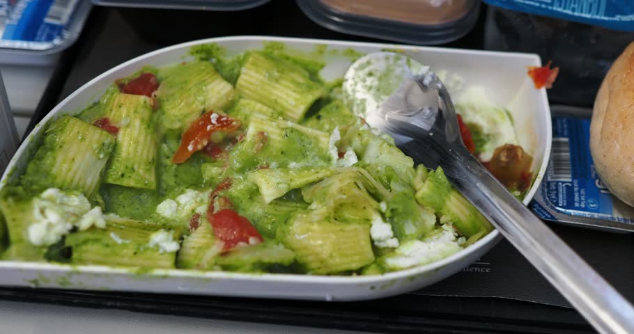 Tray of pasta with pesto and cheese served as in-flight meal on commercial flight