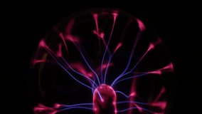 A stunning plasma globe radiates vibrant blue and pink electric arcs from its core, creating a mesmerizing and colorful display of static energy in the dark. - Powered by Shutterstock - Get 15% off with code: PIKWIZARD15