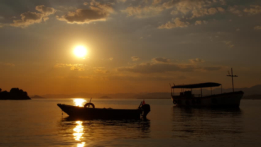 Warm sunset over docked boats. A view of evening harbor with moored boats on waves