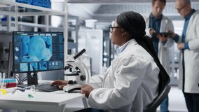 African american scientist placing tray under the microscope, slides matter for molecular and genetics research. Optics, diagnostics and analysis with advanced equipment for biochemistry. Camera B. - Powered by Shutterstock - Get 15% off with code: PIKWIZARD15
