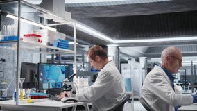 Male science expert operates with microscope and laboratory tray, studying chemical and biological samples for medical research. Magnified observation of DNA in modern science. Camera A. - Powered by Shutterstock - Get 15% off with code: PIKWIZARD15